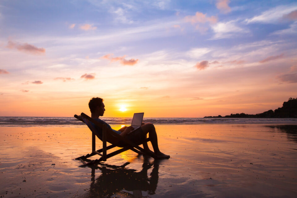 silhouette of happy business man with laptop working on the beach. silhouette of happy business man with laptop working on the beach.